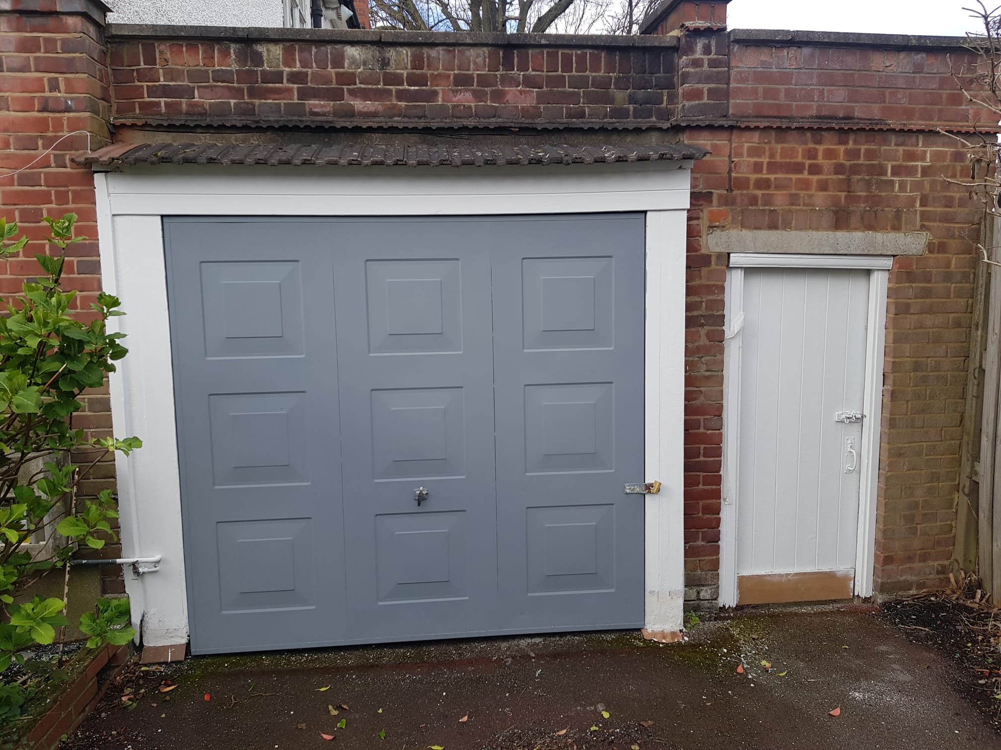Garage door after repainting, finished in fresh grey paint.