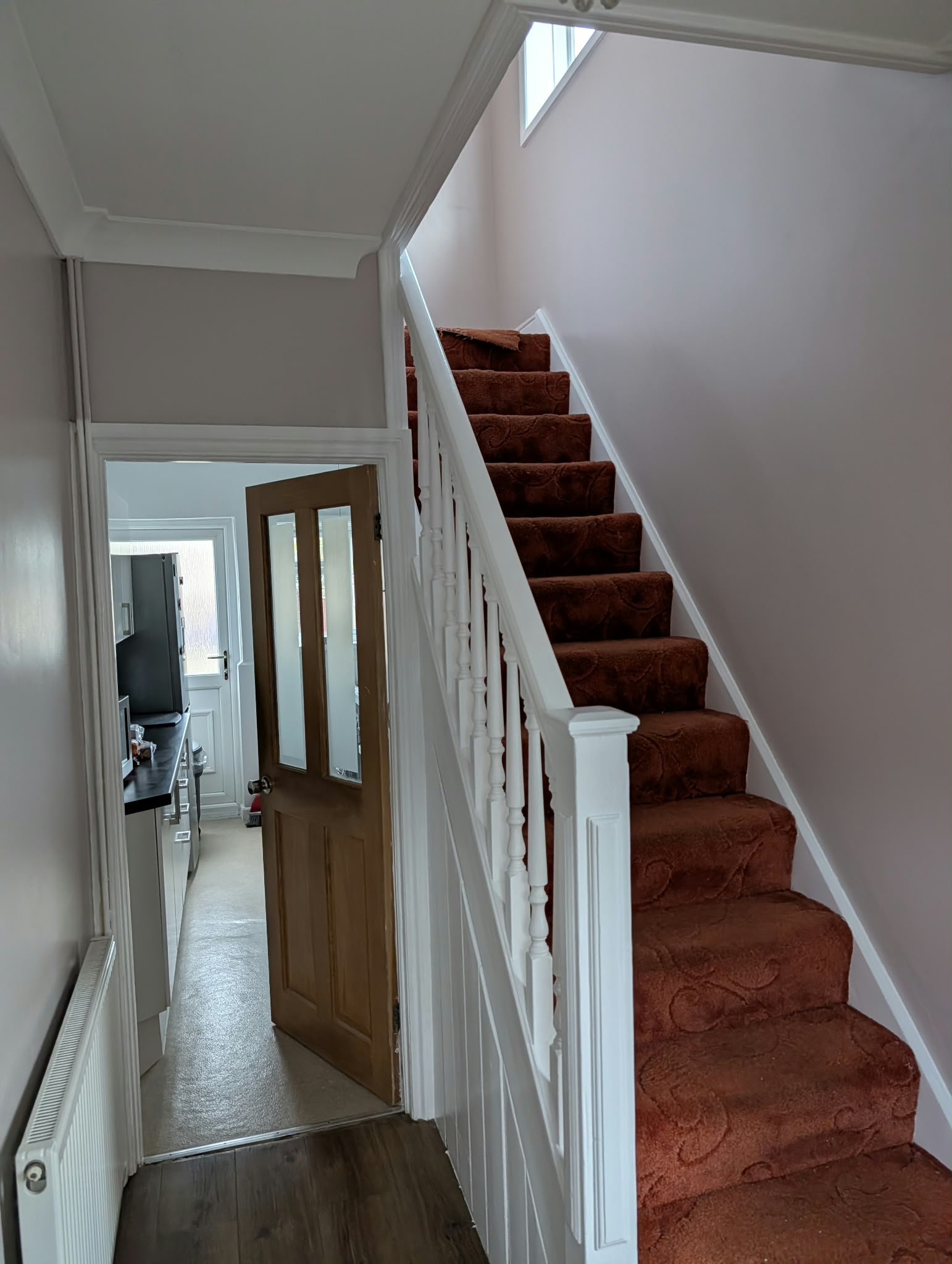 Staircase and hallway with freshly painted white woodwork and walls.